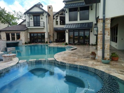Freeform Infinity Edge Pool With Silver Travertine Pavers Glass tile, and Modern Grotto